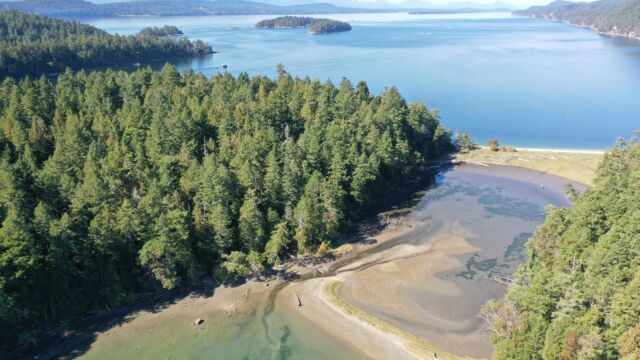 lagoon bordered by tombolo sand spits crested with shell midden and a possible intertidal fish trap